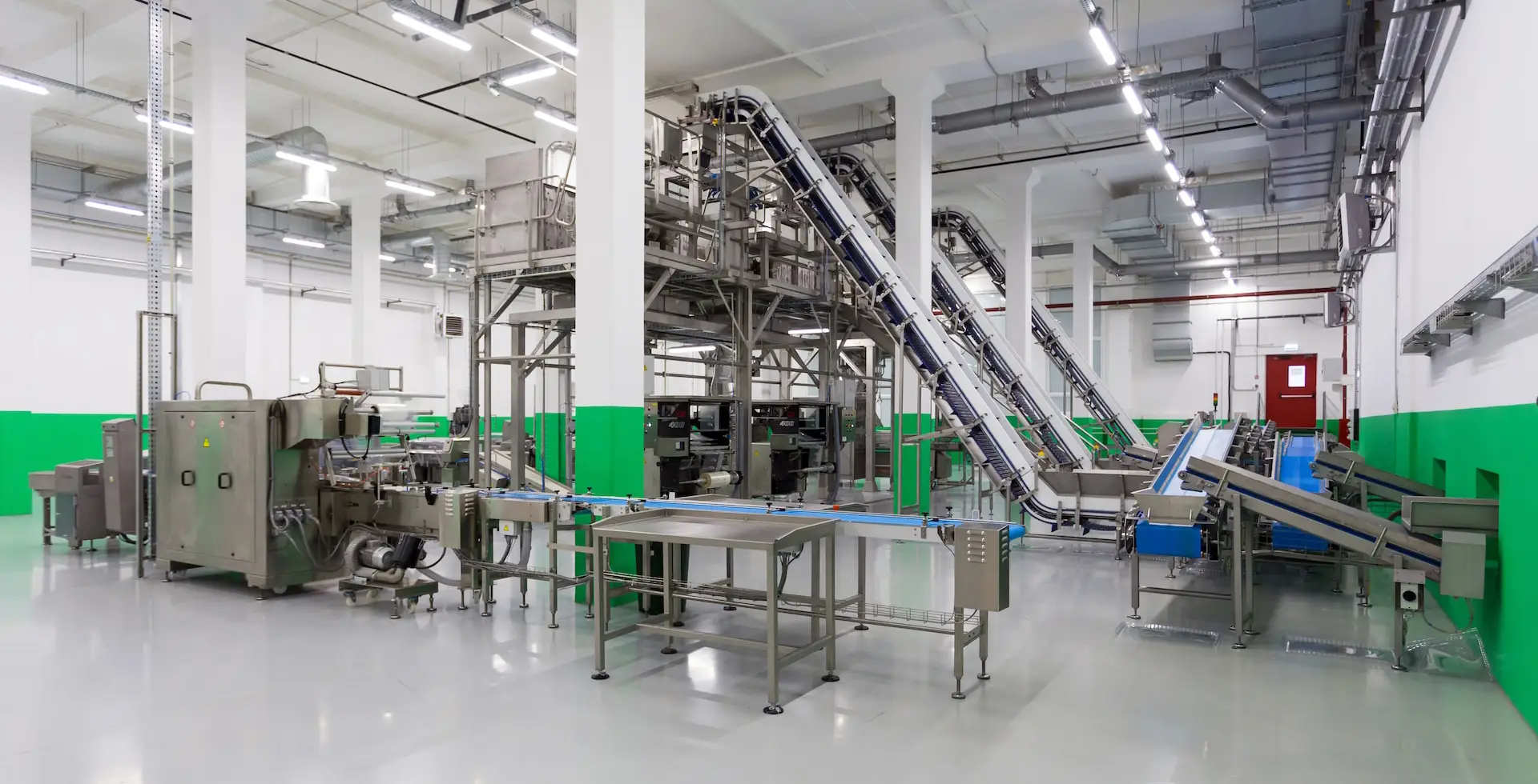 A photograph of a production line in a factory. The production line looks either new or not in use. It's only machinery, no people are visible.